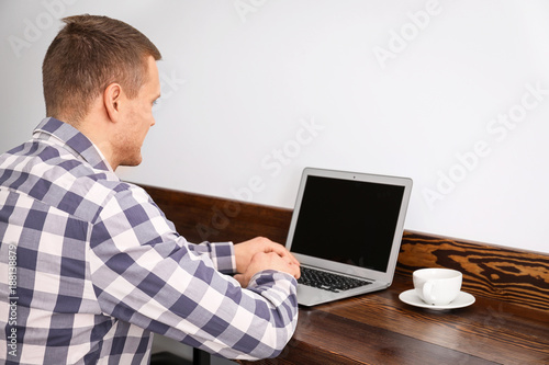 Young man using laptop at t...