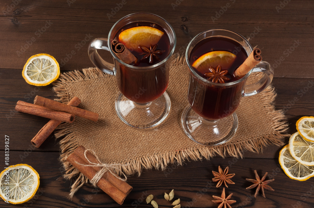 Red mulled wine on burlap on a wooden table with various spices Red mulled wine on burlap on a wooden table with various spices