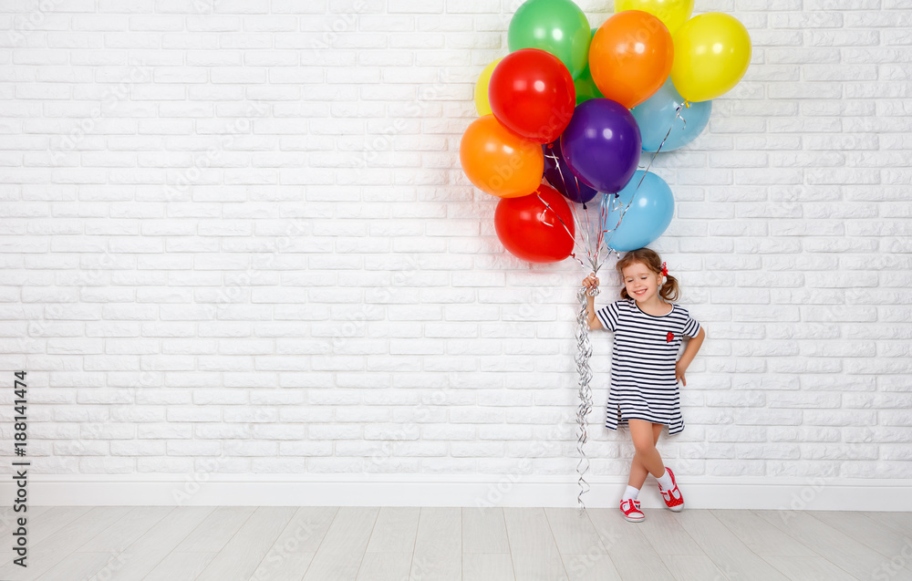 Φωτογραφία Happy funny child girl with  colorful balloons near an brick wall