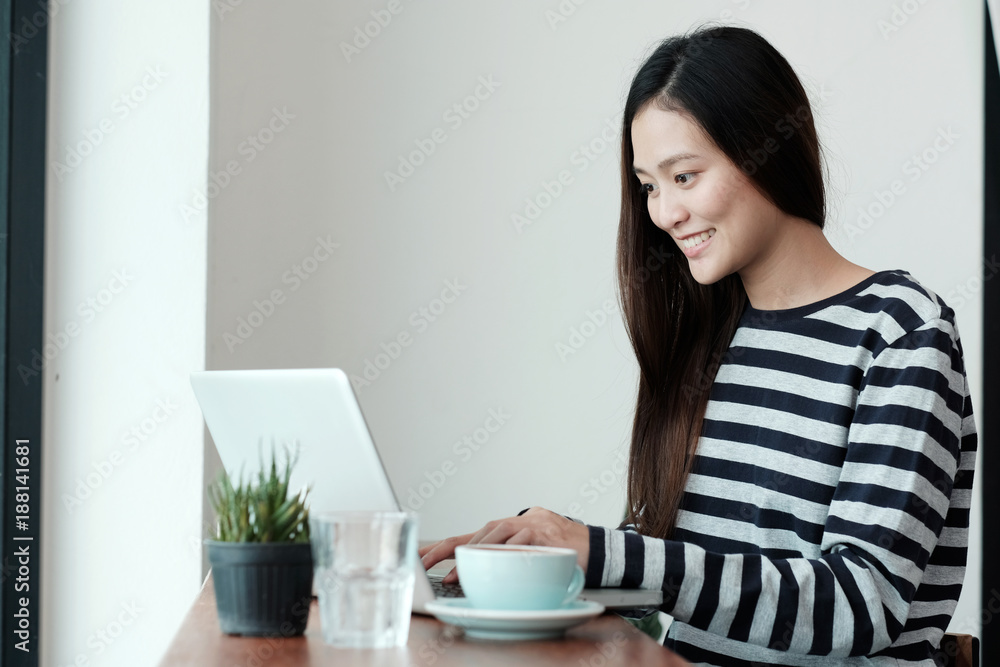 Young asian woman using laptop computer while sitting at coffee cafe background, people and technology, lifestyles Young asian woman using laptop computer while sitting at coffee cafe background, people and technology, lifestyles