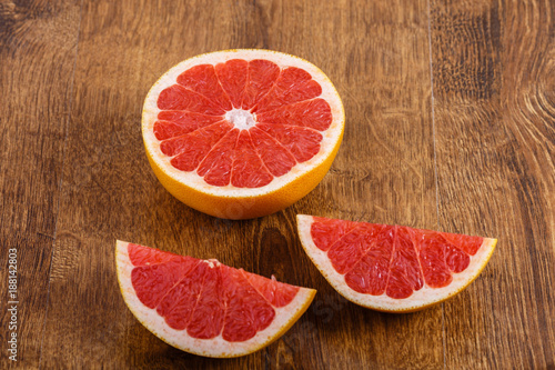 three pieces of sliced grapefruit on the wooden table