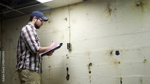 Wallpaper Mural Young Contractor looks and examines basement wall and electrical switch Torontodigital.ca