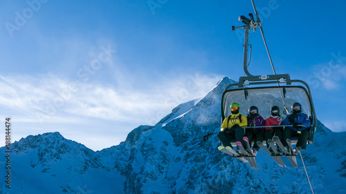 Fotografie Ski holiday - family of skiers on chairlift in high Alpine ski resort