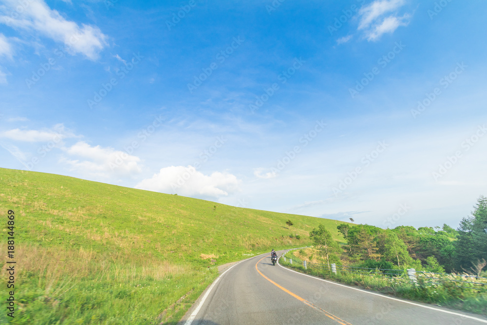 Beautiful landscape view of a country road and green grass with blue sky background of Utsukushigahara park is one of the most important and popular natural place in Nagano Prefecture , Japan. Beautiful landscape view of a country road and green grass with blue sky background of Utsukushigahara park is one of the most important and popular natural place in Nagano Prefecture , Japan.
