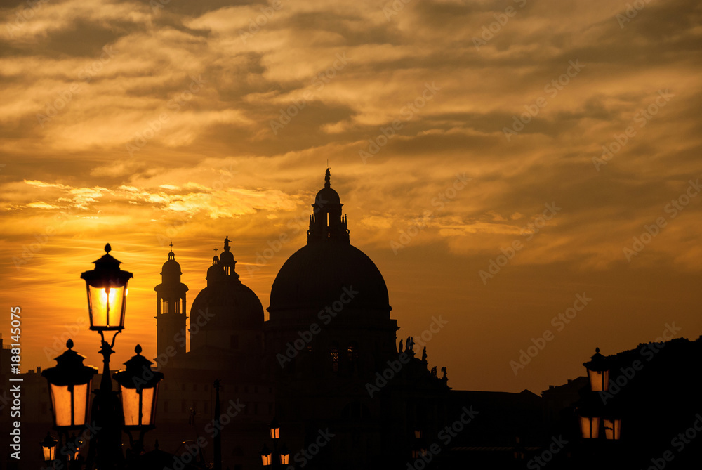 Venice sunset with Salute Basilica domes and lamps