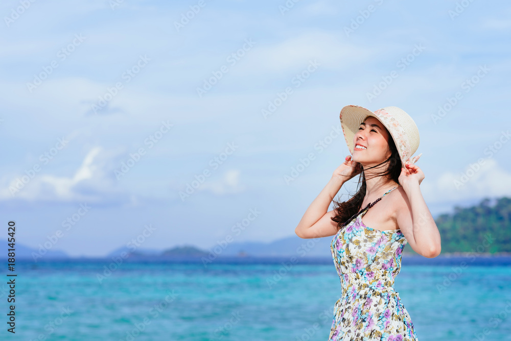 Happy delightful beautiful young Asian woman enjoying a day at the beach with clear blue sky in background Happy delightful beautiful young Asian woman enjoying a day at the beach with clear blue sky in background