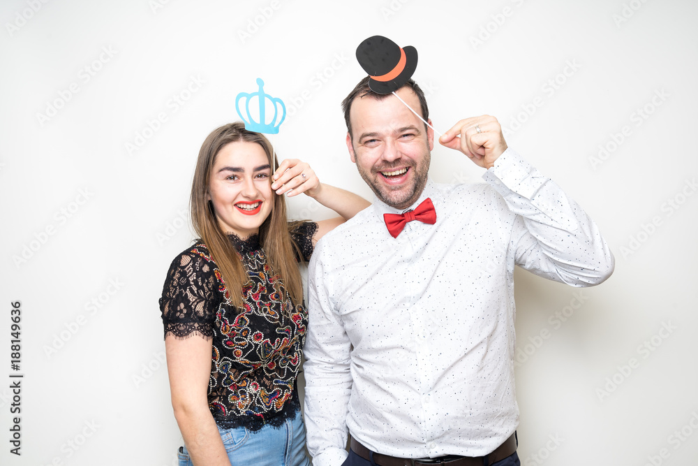 young couple friends pose photo booth funny props