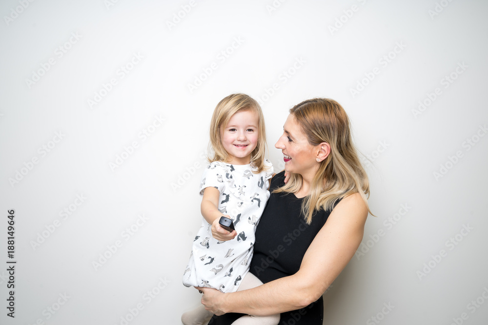 mom daughter pose camera remote control selfie studio white background