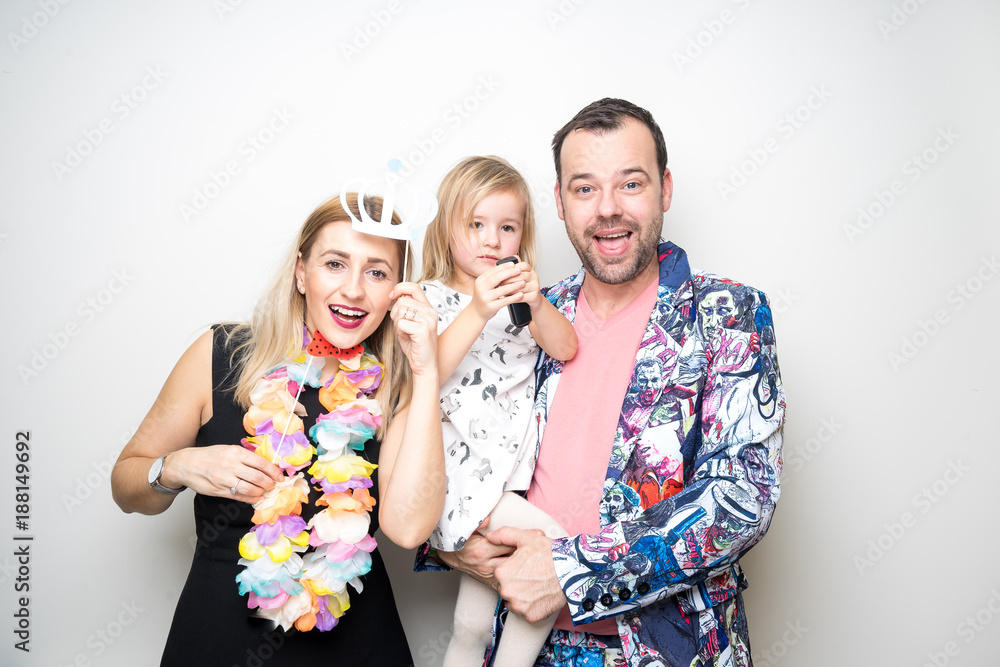 young family mom dad daughter pose photo booth funny props