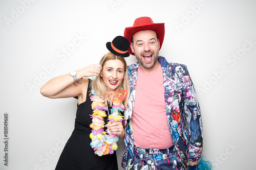 young couple funny props pose photo booth plain background