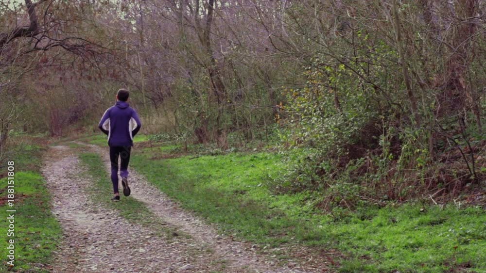 Male runner in grey skinny sport suit, training outdoors in autumn park or forest Male runner in grey skinny sport suit, training outdoors in autumn park or forest