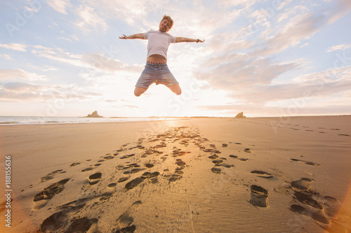 Mann springt am Strand photo