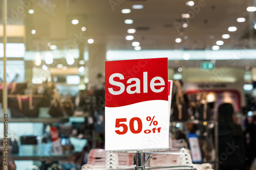 sale 50% mock up advertise display frame setting over the stack of shirt in the shopping department store for shopping, business fashion and advertisement concept