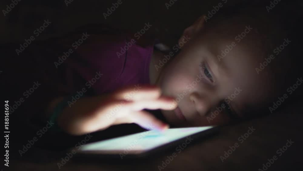 The child uses a mobile phone at night. The child uses a mobile phone at night.