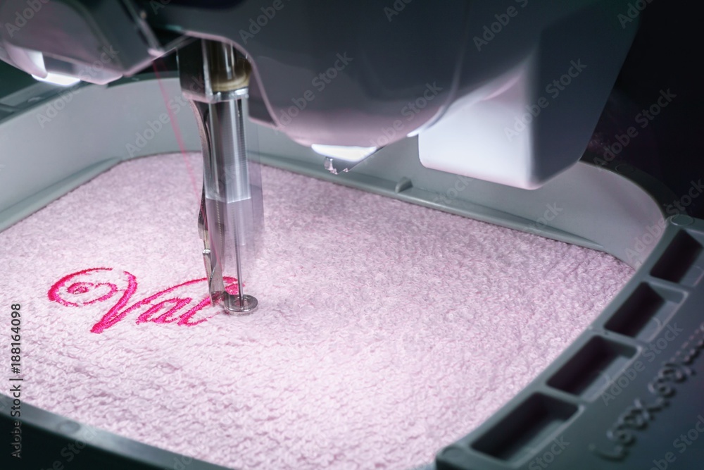 Obraz premium Embroidery machine embroidering on pink towel in the hoop Close up image