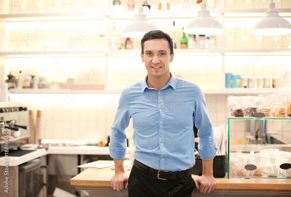 Young man standing in store. Small business owner portrait Young man standing in store. Small business owner portrait