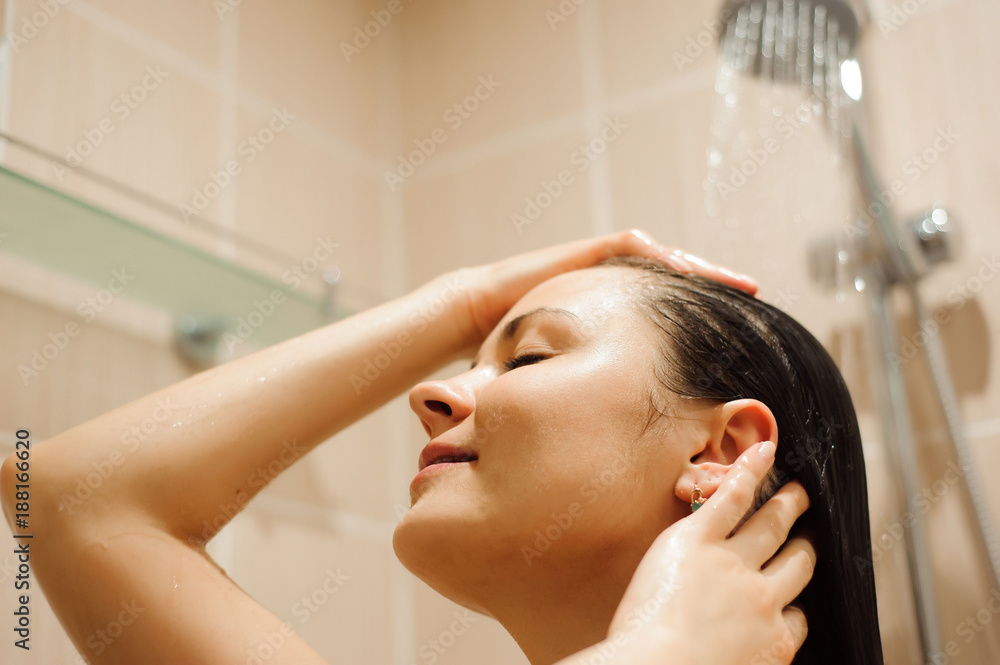 Naklejka premium Woman with long hair taking shower.