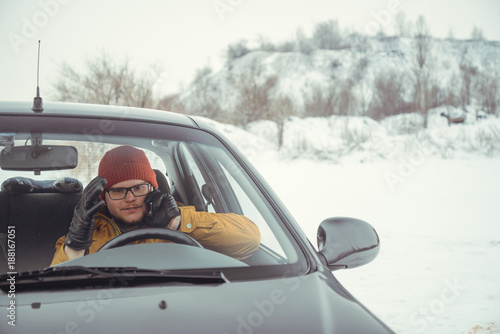 man talking by phone while sitting in the car