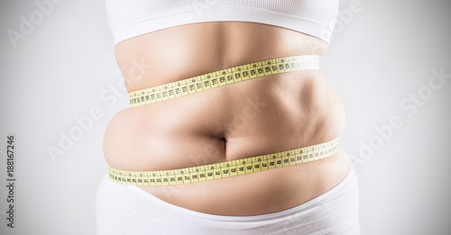 Foto Overweight woman measuring her fat belly.