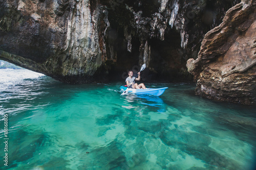 kayaker paddling in crystal clear water near the cave on Railay beach in Krabi, tourist travel on kayak in Thailand, blurred motion © Song_about_summer