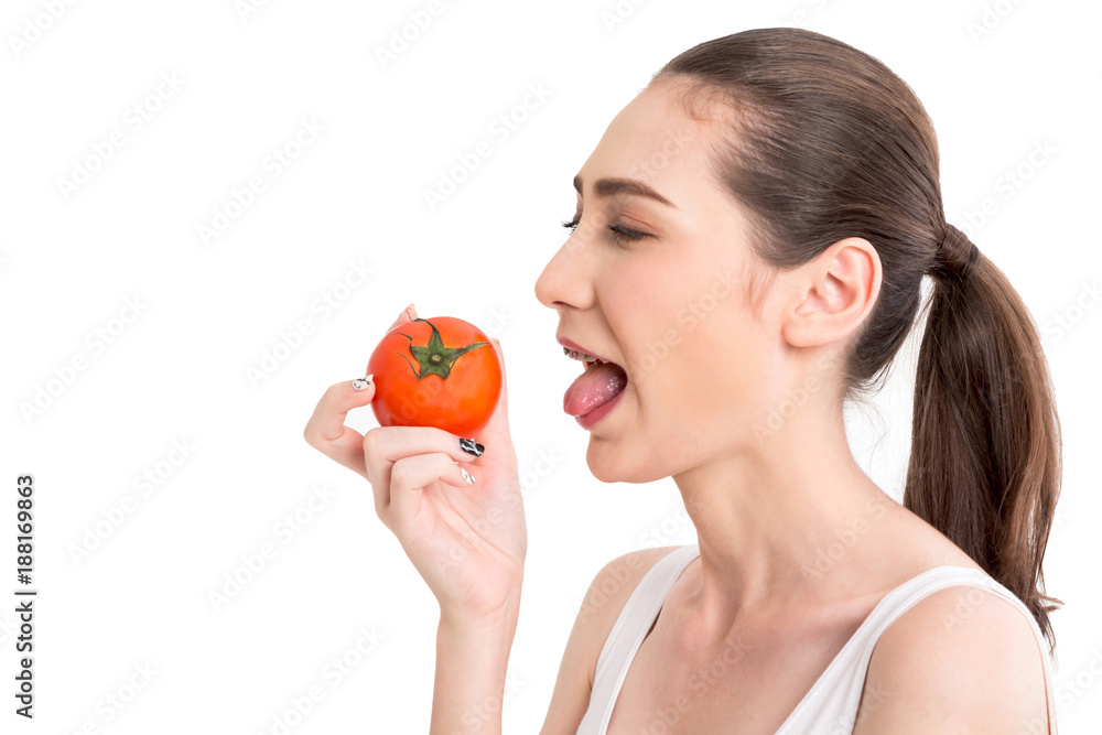 Beautiful woman holding a red tomato isolated on white background Beautiful woman holding a red tomato isolated on white background