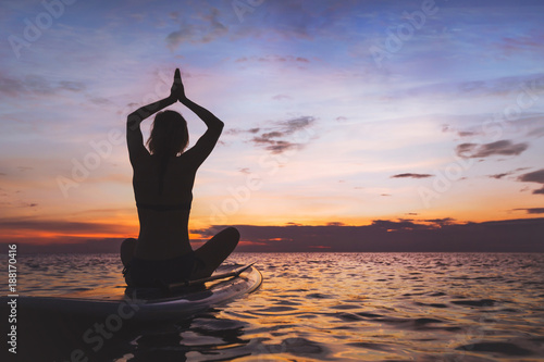 yoga on sup board, silhouette of woman on the beach