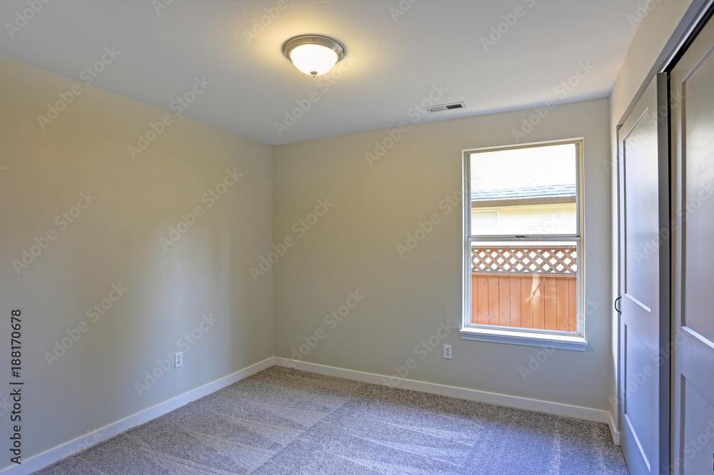 Fototapeta premium Empty room interior with beige walls and wall to wall carpet.