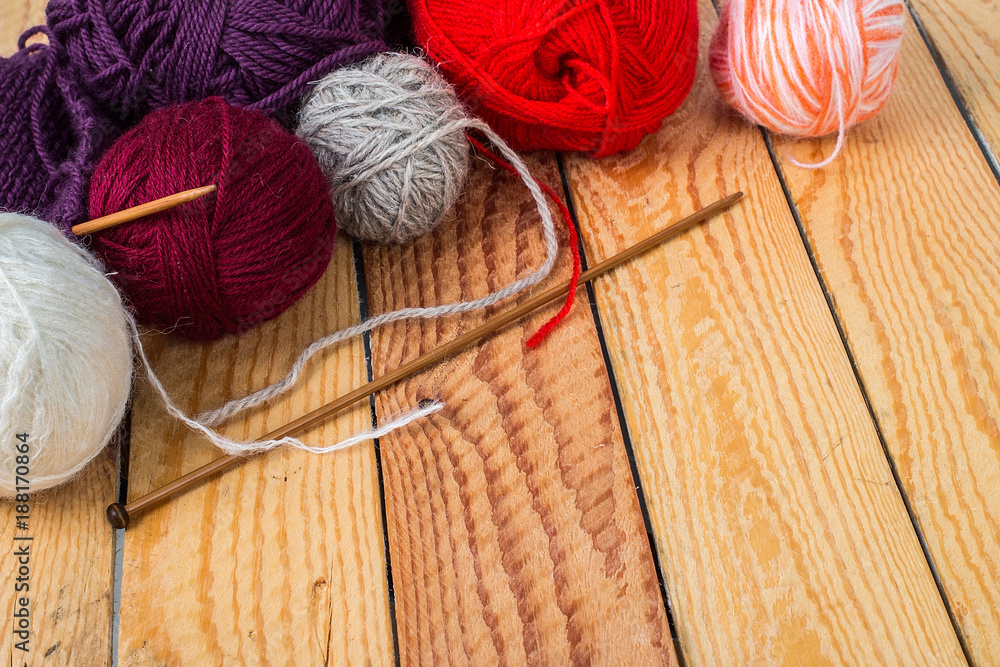 Colorful yarn balls on a wooden background 