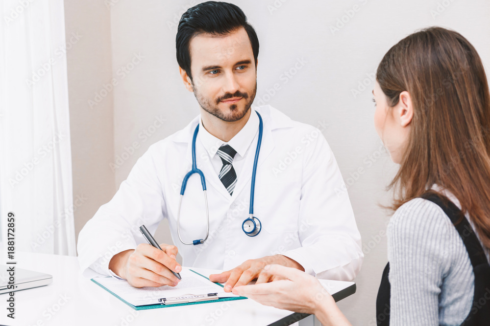 Doctor medical check up information with woman patient on doctors table in hospital.healthcare and medicine Doctor medical check up information with woman patient on doctors table in hospital.healthcare and medicine