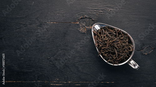 Dry black tea. On a wooden background. Top view. Copy space.