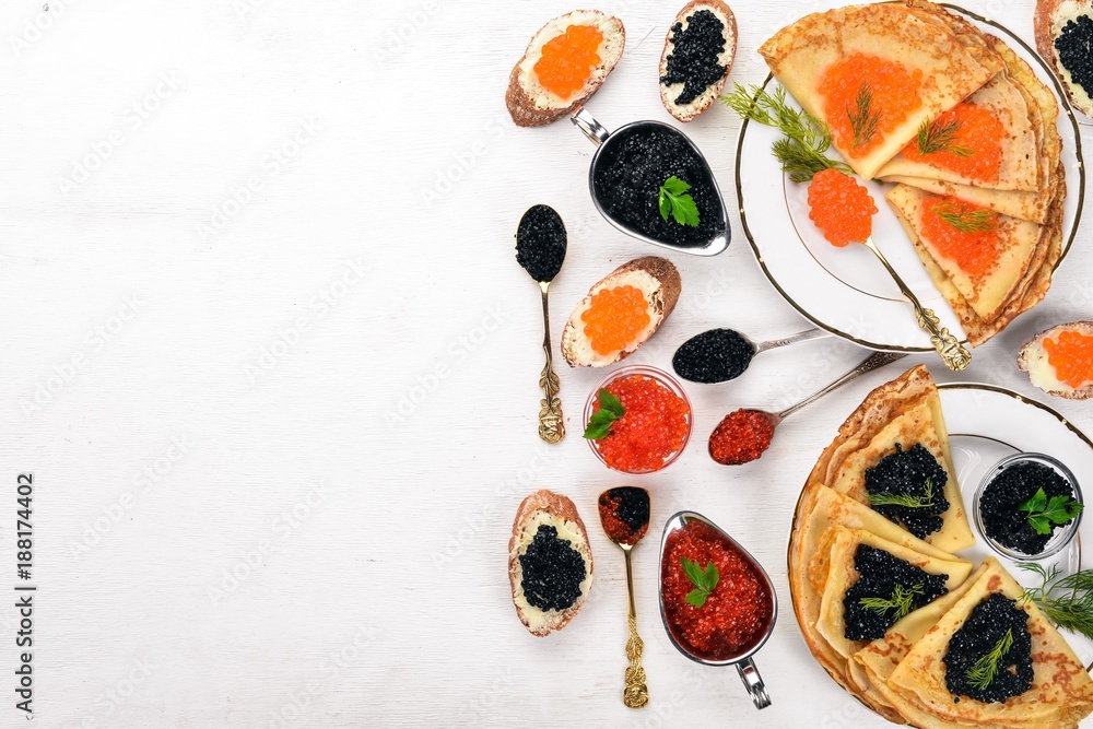 Pancakes with caviar. On a wooden background. Top view. Free space for text.
