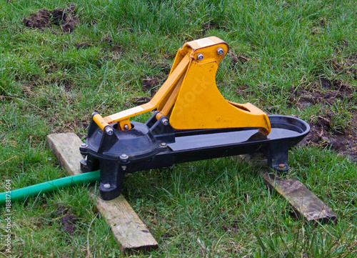 Yellow livestock nose pump in a meadow photo