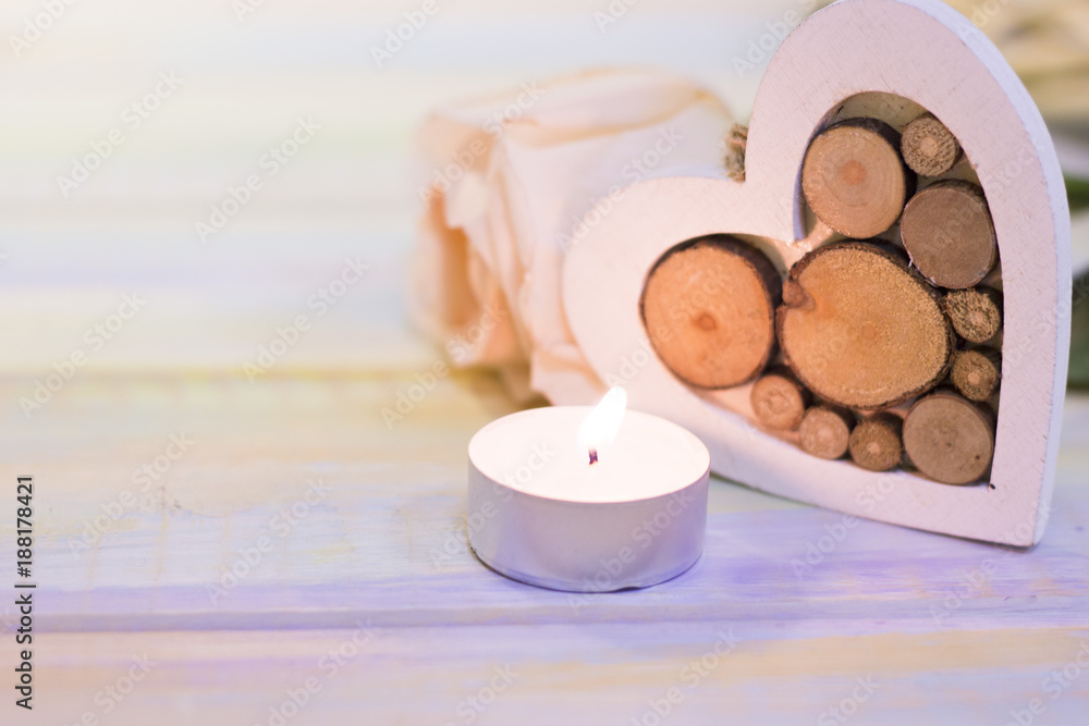 The concept of St. Valentine's Day, Love, Wedding, Anniversary with a beautiful cream rose, a wooden heart and a burning candle, close up, light blurred background The concept of St. Valentine's Day, Love, Wedding, Anniversary with a beautiful cream rose, a wooden heart and a burning candle, close up, light blurred background