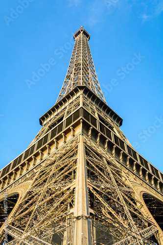 Symmetrical low angle view of the Eiffel Tower against blue sky.