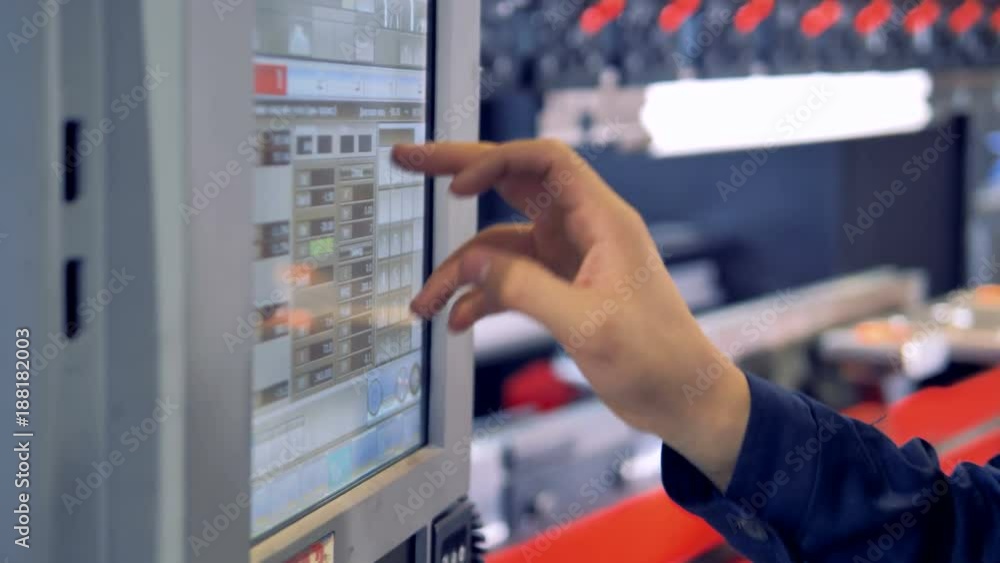 Operators press and choose necessary settings on a CNC steel processing machine. Operators press and choose necessary settings on a CNC steel processing machine.