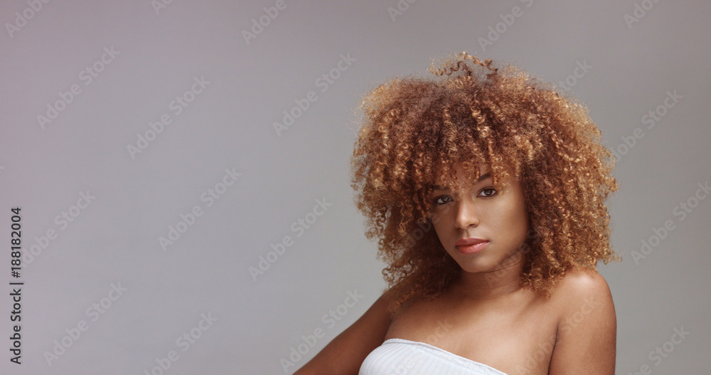 mixed race black woman with neutral makeup portrait. Curly hair ideal skin, studio, grey background mixed race black woman with neutral makeup portrait. Curly hair ideal skin, studio, grey background