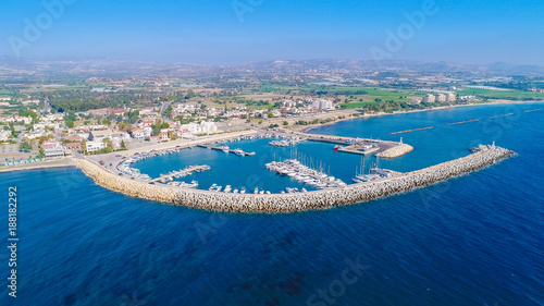 Aerial bird's eye view of Zygi fishing village port, Larnaca, Cyprus. The fish boats moored in the harbour with docked yachts and skyline of the town near Limassol from above. photo