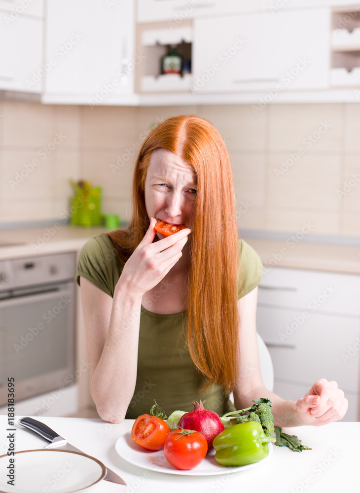 Skinny girl eating tomato
