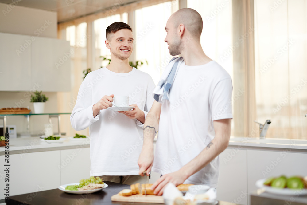 Homosexual couple having talk while cooking breakfast at home Homosexual couple having talk while cooking breakfast at home