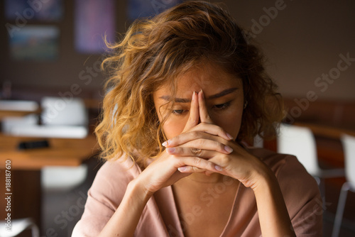 Tired Young Woman Leaning Head on Hands photo