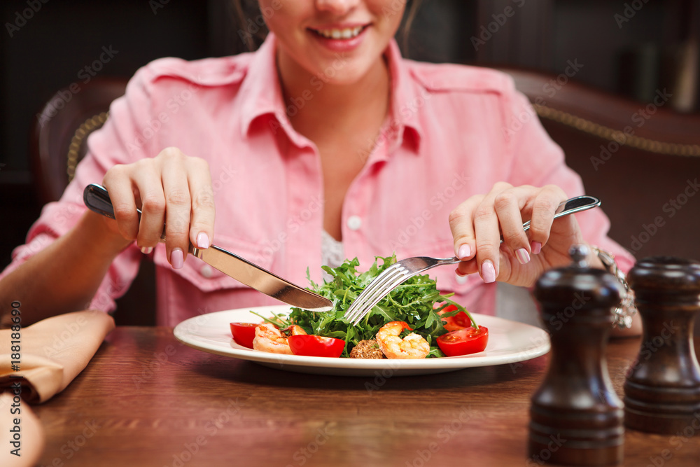 Delighted woman show tongue and going to eat salad with arugula Delighted woman show tongue and going to eat salad with arugula