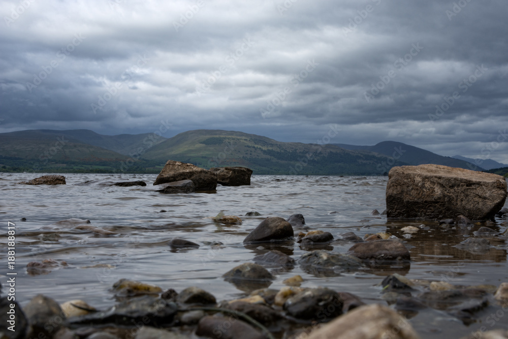Rocks leading out into the fresh water of Loch Lomond Scotland