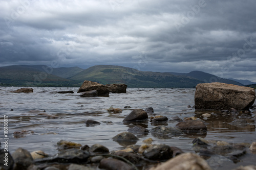 Rocks leading out into the fresh water of Loch Lomond Scotland