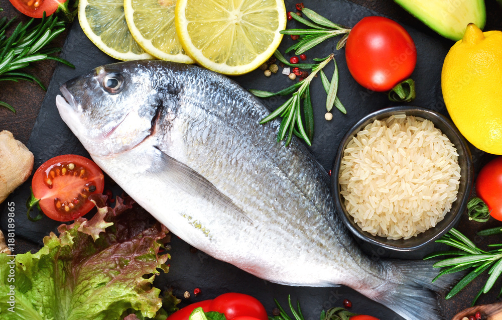 Food background. Fresh, raw Dorado with a swallow, lemon, avocado on a dark concrete background. Food background. Fresh, raw Dorado with a swallow, lemon, avocado on a dark concrete background.