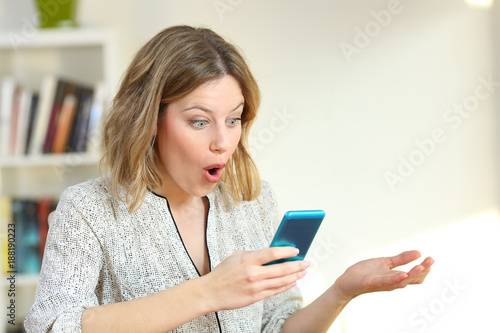 Surprised girl watching online content in a blue phone