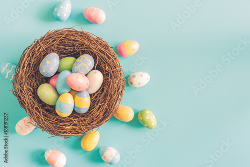 Photography Coloeful easter eggs in nest on pastel color background with space