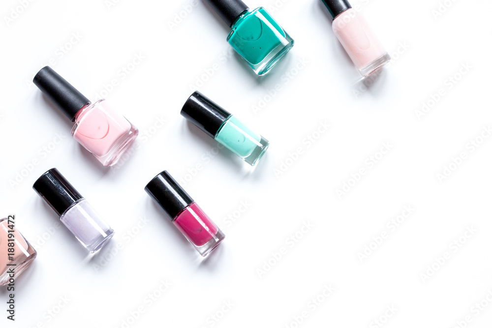 Obraz premium Bottles with nail polish over white background top view mockup