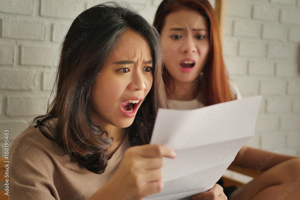 frustrated, shocked women looking at expensive bill or debt notice invoice frustrated, shocked women looking at expensive bill or debt notice invoice