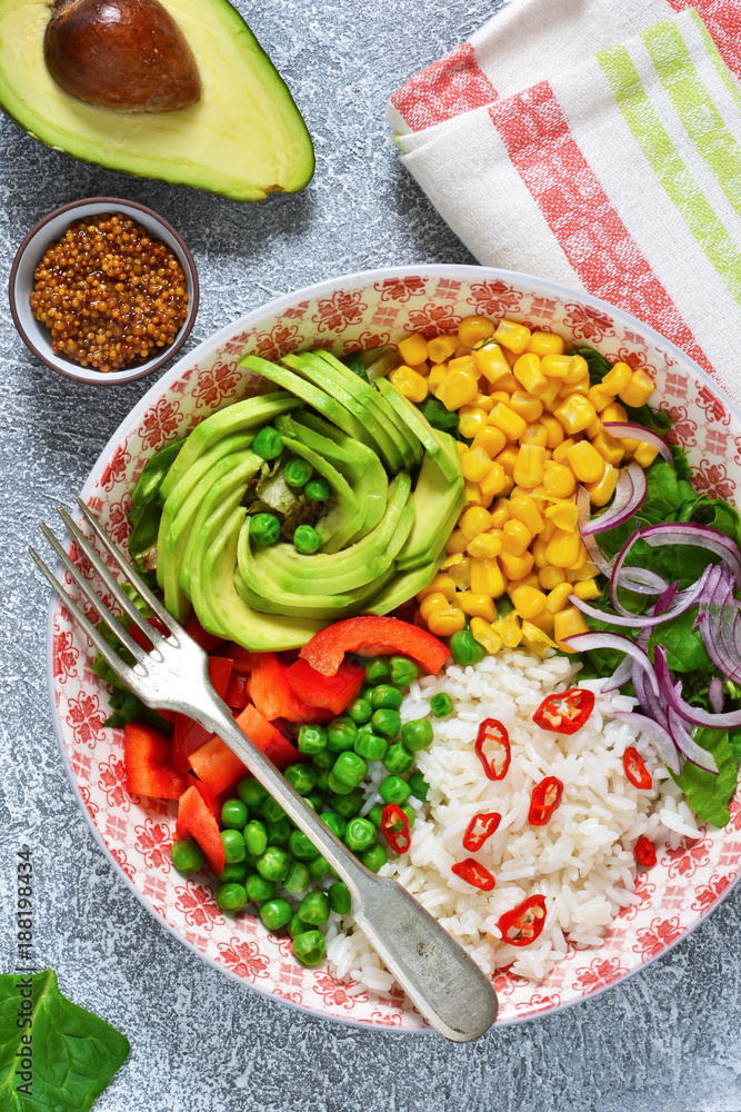 Plate with salad, corn, avocado and rice on a concrete background!