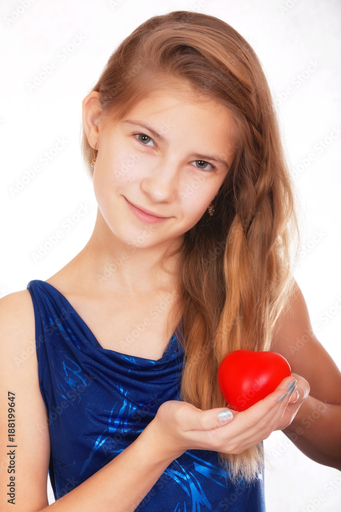 Valentine's day. Smiling beautiful teen girl with a symbolic gift in the form of a red heart Valentine's day. Smiling beautiful teen girl with a symbolic gift in the form of a red heart